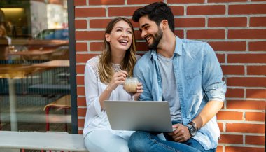 Kafede oturup tabletle eğlenen genç ve güzel bir çift. Tatilde kafede öğrenciler. Aşk, romantizm, randevu, yaşam tarzı, eğitim