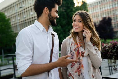 Dışarıda dijital cihazları olan mutlu bir iş adamı ve kadın. İş insanları mutluluk konsepti