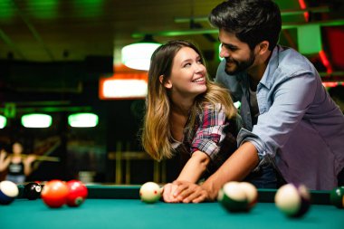 Barda bilardo oynarken eğlenen mutlu genç çift. İnsanlar eğlence konsepti