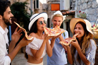 Arkadaşlar eğleniyor ve pizza yiyorlar. Randevu, tüketim, seyahat, yemek ve yaşam tarzı konsepti.