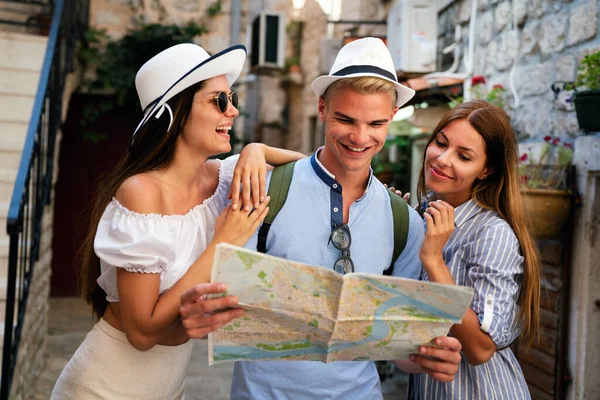 度假和友谊概念 度假时朋友们带着地图鬼鬼祟祟的 — 图库照片