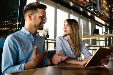 İş projesi ekibi şirket ofisindeki toplantı odasında birlikte çalışıyor.