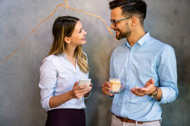 Mutlu iş arkadaşları kahve molası sırasında sohbet ediyorlar.