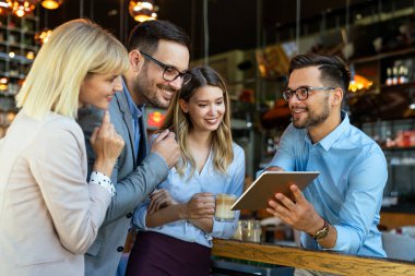 İş adamları işyerinde çalışıyor, eğleniyor ve sohbet ediyorlar.