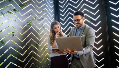 İş projesi ekibi şirket ofisindeki toplantı odasında birlikte çalışıyor.