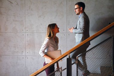 Şirket binasında yürüyen ve merdivenleri çıkan bir grup iş adamı.