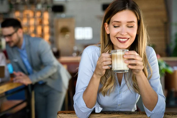 休憩中にコーヒーを飲む幸せな若い成功したビジネス女性の肖像画 背景には彼女の同僚が — ストック写真