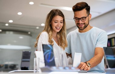 Yeni bir dijital cihaz alıyorum. Mutlu çift mağazadan bir cep telefonu alıyor..