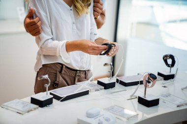 Mutlu gençler mağazadan yeni dijital cihazlar alıyorlar. Teknoloji akıllı saat alışveriş cihazı konsepti