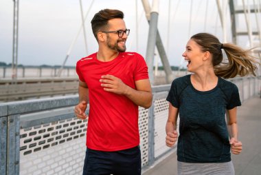 Sabah sporu. Köprüden koşarak geçen mutlu çift. Spor yaşam tarzı sağlıklı..