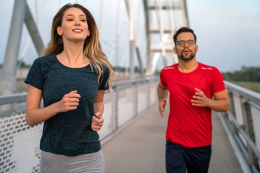 Sabah sporu. Köprüden koşarak geçen mutlu çift. Spor yaşam tarzı sağlıklı..