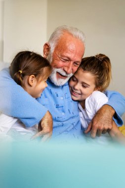 Büyük dedesi olan mutlu çocuklar birlikte eğleniyor ve gülüyor. Aile, destek, eğlence konsepti