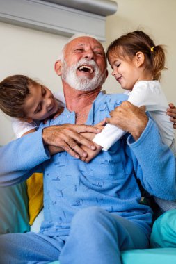 Büyük dedesi olan mutlu çocuklar birlikte eğleniyor ve gülüyor. Aile, destek, eğlence konsepti