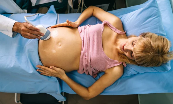 Pregnant woman during ultrasound scanning at the hospital, clinic. Healthcare, examination, pregnancy, gynecologist concept.
