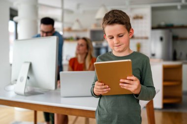 Evde eğitim sosyal mesafesi e-öğrenim online eğitim kavramı. Evde tablet kullanan mutlu okul çocuğu..