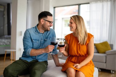 Romantik bir buluşma yaşayan ve şarap içen genç ve mutlu bir çift. Çiftler aşk konseptini sever.