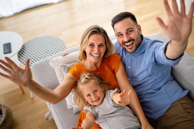 Mutlu genç aile evde eğleniyor. Ebeveynler, çocuklar mutluluk kavramını sever.