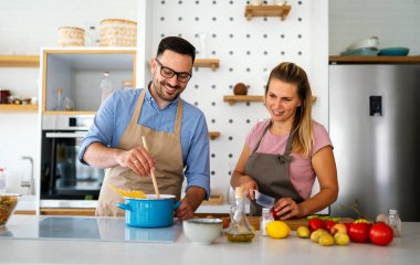 Genç mutlu çift mutfaklarında birlikte sağlıklı bir yemek hazırlıyor. İnsanlar yemek mutluluk konsepti.