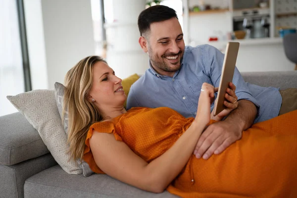 Portrait of happy young couple with tablet,watching something online. People digital device concept.