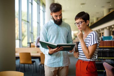 Bir kolej kütüphanesinde birlikte çalışıp çalışan bir grup başarılı öğrenci. Eğitim insanları öğrenme kavramı.