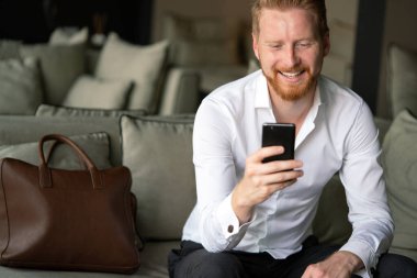 Akıllı telefon kullanan başarılı genç bir iş adamı.