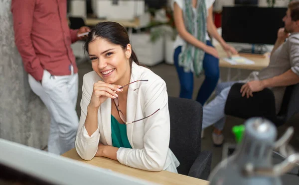 Group of software engineers working developing applications together in corporate office. Happy multiethnic business coworkers brainstorming at workplace.