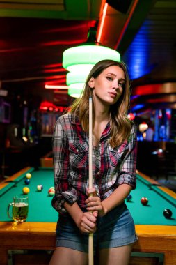Genç güzel kız bilardo oynuyor. Keyifli zaman geçirme, dinlenme, eğlence konsepti