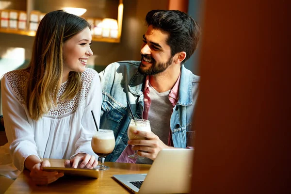 Kafede oturup tabletle eğlenen genç ve güzel bir çift. Tatilde kafede öğrenciler. Aşk, romantizm, randevu, yaşam tarzı, eğitim