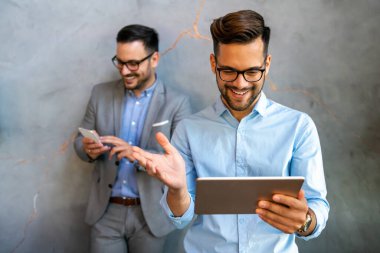 Çeşitli iş arkadaşları ofiste dijital aletlerle gülüp eğleniyor. Arkadaşların internetten komik videolar izlemesi veya mobil uygulamalar kullanması