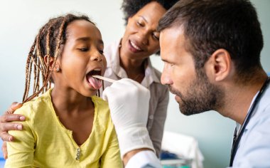 Genç erkek çocuk doktoru, muayenehanedeki kız çocuğu muayene eden doktor. Sağlık hizmetleri önleme sınavı insanları kavramı