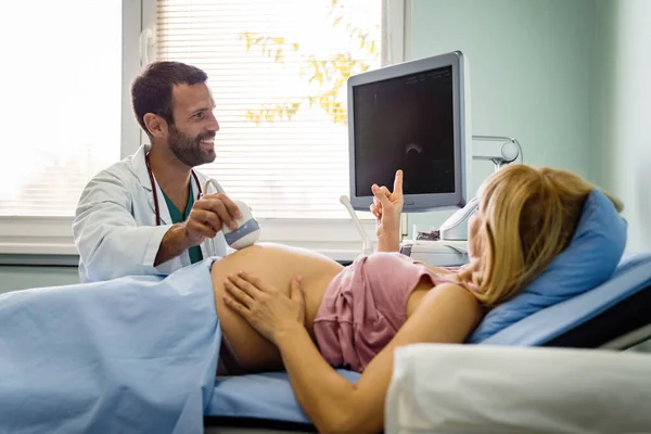 Obstetrician examining pregnant woman belly by ultrasonic scan in hospital. Healthcare, gynecologist, maternity concept.