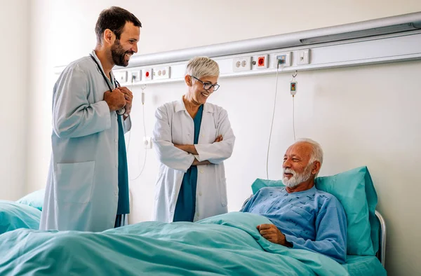 Doctors consulting a mature man patient in hospital. Healthcare people insurance concept