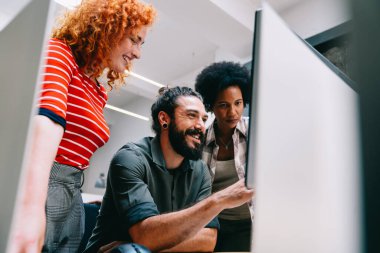 Gülümseyen çeşitli meslektaşlar toplantı odasında toplanmış mali istatistikleri tartışıyorlar. Mutlu çok ırklı iş arkadaşları ofis toplantılarında işbirliği yaparken eğleniyorlar. Takım çalışması konsepti.