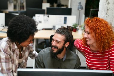 Genç yaratıcı pazarlama uzmanlarından oluşan bir ekip, teknoloji ve kablosuz bağlantı kullanarak konferansta şirket paylaşımı için reklam stratejisi üzerinde çalışırken beyin fırtınası yapıyor.