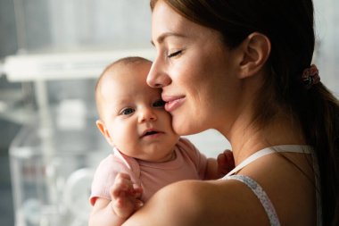 Neşeli aile kavramı. Anne ve bebek öpüşüyor, gülüyor ve sarılıyor.