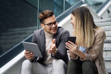 İş adamları, şehir planındaki işyerinde eğleniyor, çalışıyor ve sohbet ediyorlar.