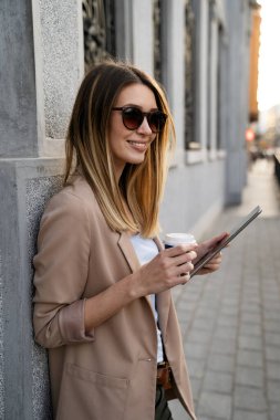 Şehir planında dijital tablet kullanan başarılı genç kadının portresi. İş adamları konsepti