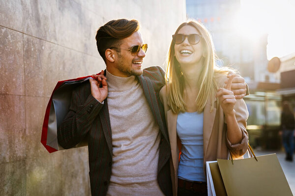 Portrait of happy young couple with shopping bags. People sale consumerism and lifestyle concept.