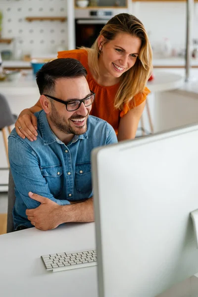 Happy couple doing business together working at small office. People work technology concept.