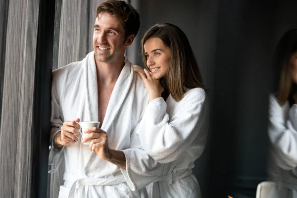 一緒にコーヒーを飲む白いバスローブの幸せな若いカップル ホテル 幸福の概念 — ストック写真
