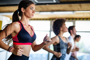 Sağlık kulübünde koşu bandında koşan sağlıklı genç insanlar..