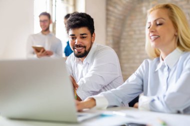 Birlikte yeni bir proje üzerinde çalışıyoruz. Çok ırklı iş adamlarından oluşan mutlu bir grup ofiste bir takım olarak işbirliği yapıyor.