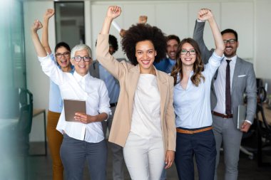 Çok ırklı iş adamlarından oluşan mutlu bir grup ofiste iyi bir işi kutluyor. İş ve finans kavramı.