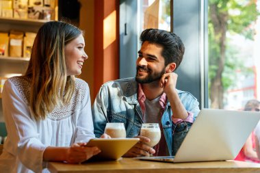 Happy couple in love using digital devises for work, study or social media. People technology concept