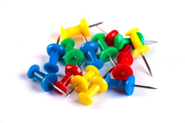 Closeup of Many Colored Thumbtacks on White. Object