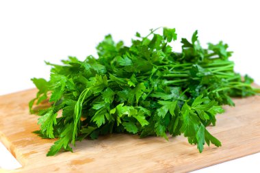 Bunch of fresh parsley and coriander vegetables on a wooden board, white background. Vegetable