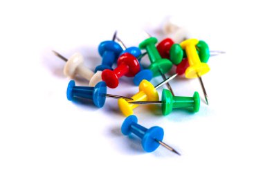 Closeup of Many Colored Thumbtacks on White. Object