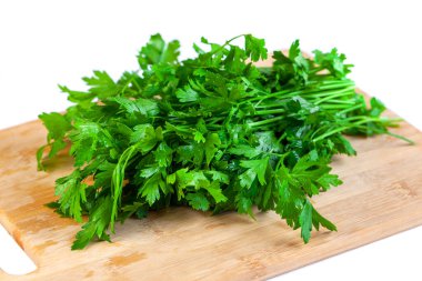 Bunch of fresh parsley and coriander vegetables on a wooden board, white background. Vegetable