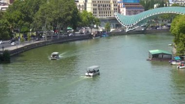 Tbilisi, Georgia - 23 August, 2022: Pleasure tourist boats on the river Mtkvari in the city of Tbilisi