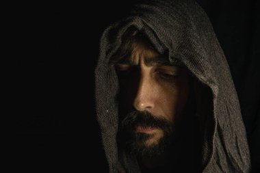 Face of young man with dark hat and black background